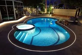 White perimeter lighting around a curved swimming pool