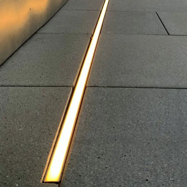 Warm white recessed linear LED channel between outdoor paving slabs