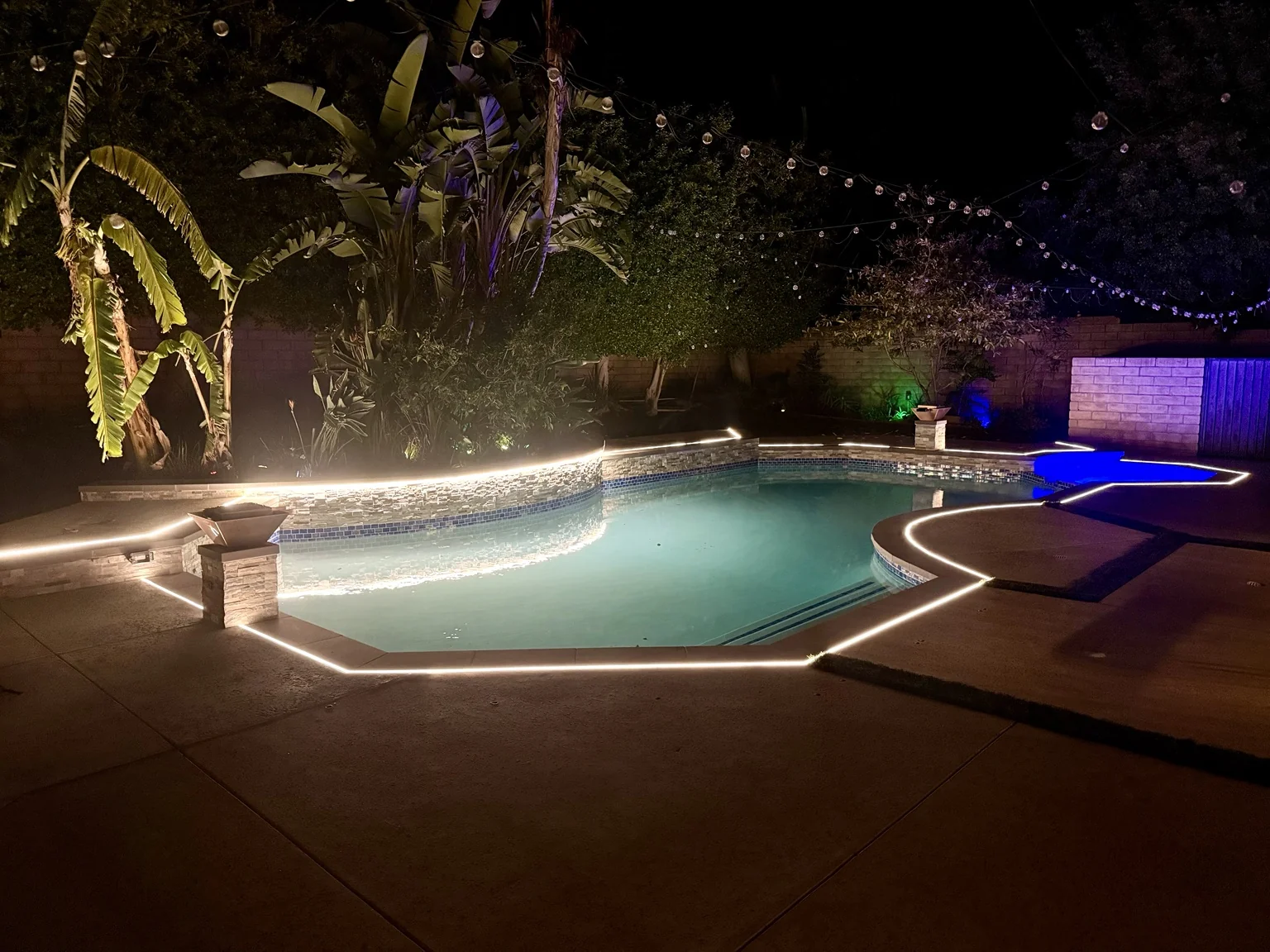 Warm white LED lighting around a backyard pool